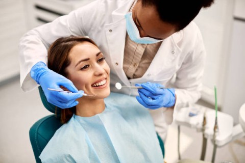 A woman undergoing a dental check-up, highlighting a routine dental procedure with a dentist examining her teeth.